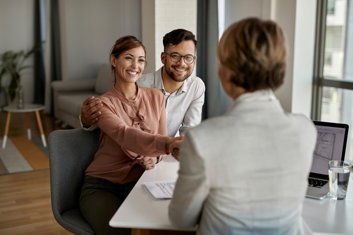 jeune couple qui vient de signer un contrat avec un agent d'entreprise